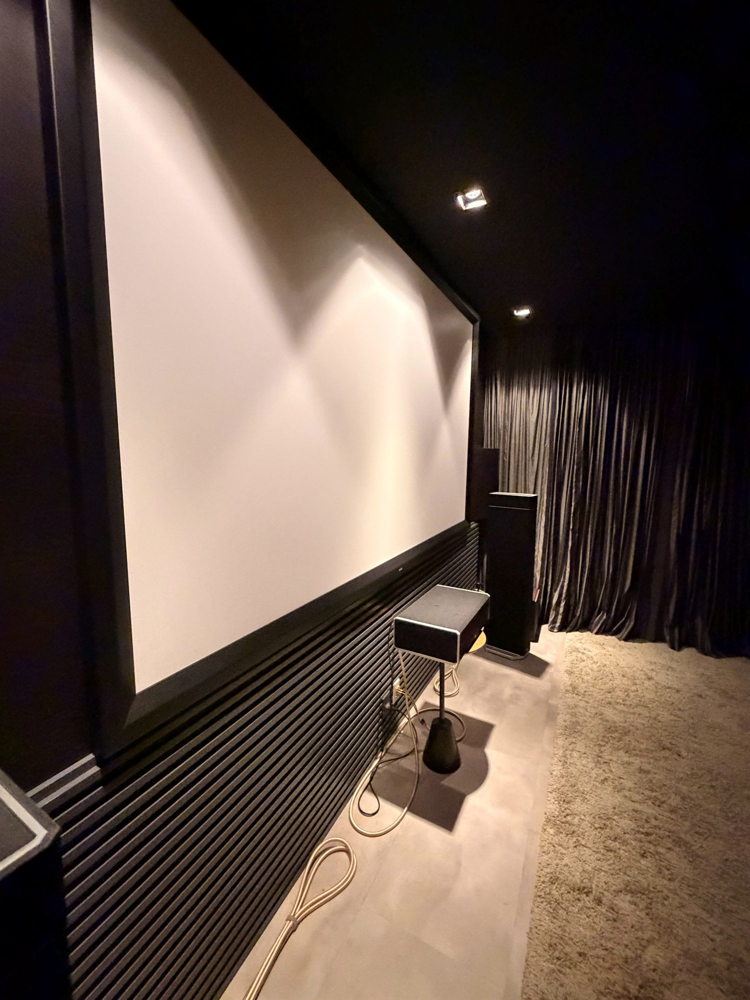 Sala de home theater residencial em Manaus com projetor de alta definição e tela grande, ambiente escurecido com poltronas de lounge