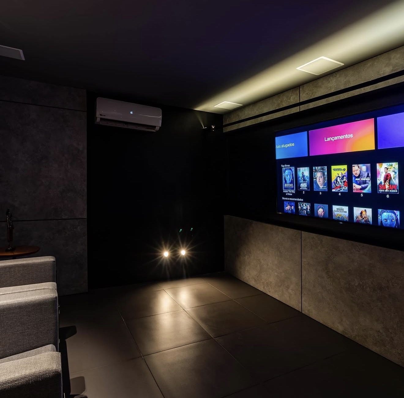 Tela de projeção de home theater residencial com sistema de som surround instalado nas paredes